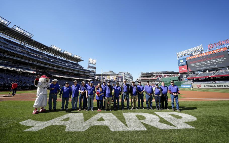 The veterans stand on the field to be recognized.